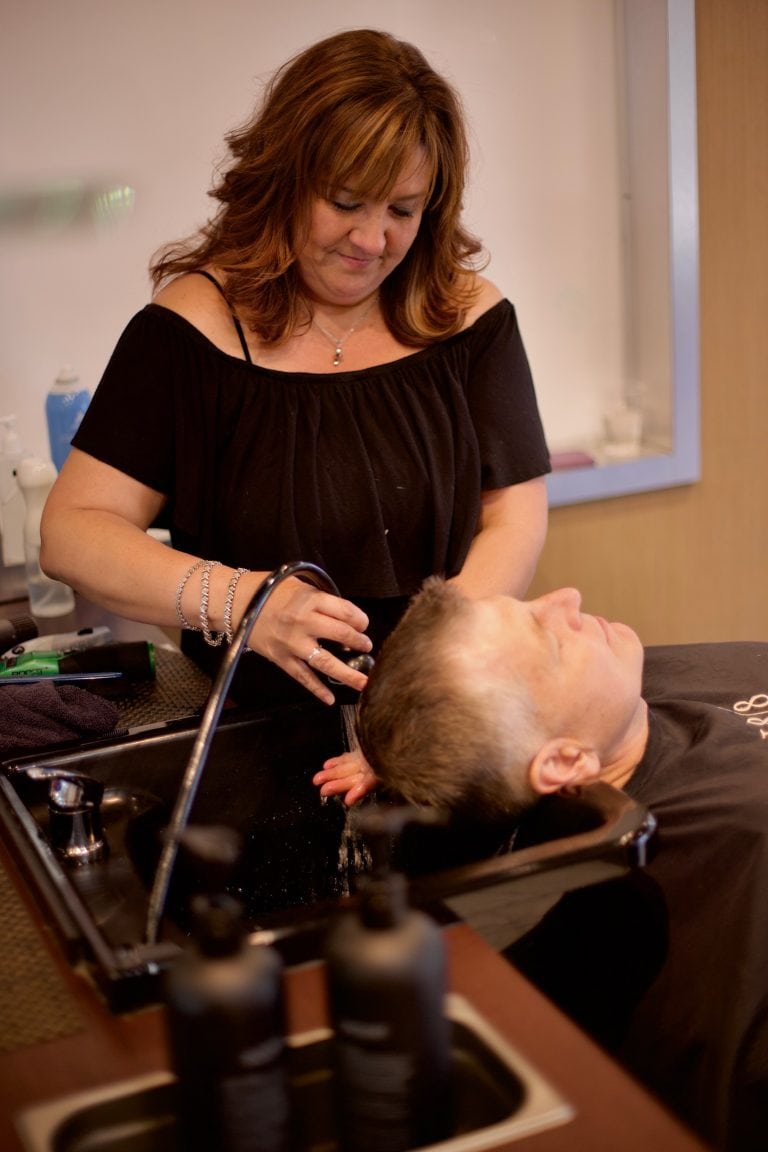 Stylist Washing Men's Hair in Salon
