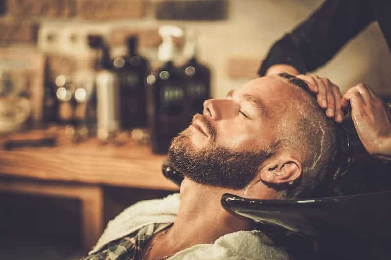 Man getting his hair washed at a men's salon and barbershop